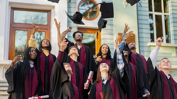 Graduates throwing cap in air