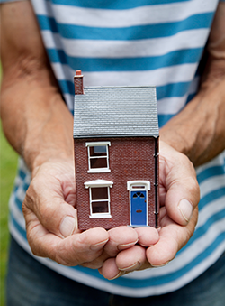 Hand holding a model townhouse